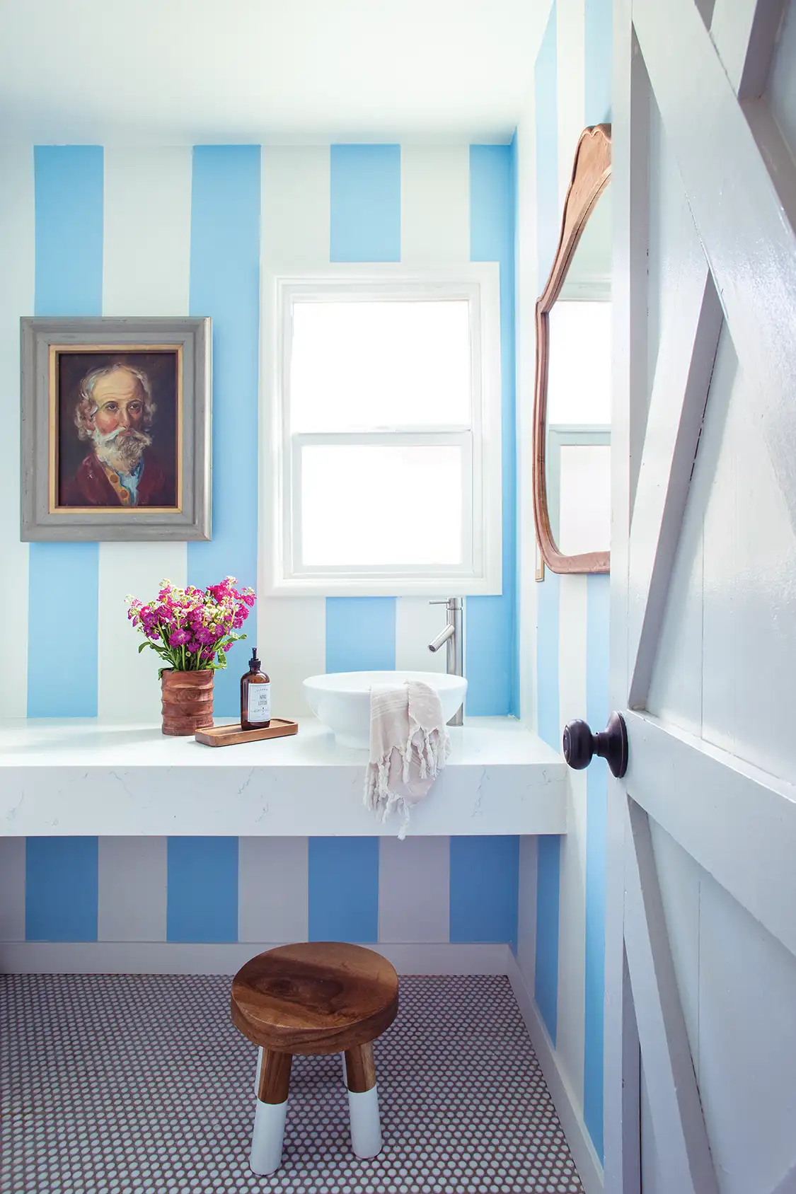 blue and white striped wallpaper in bathroom of renovated home