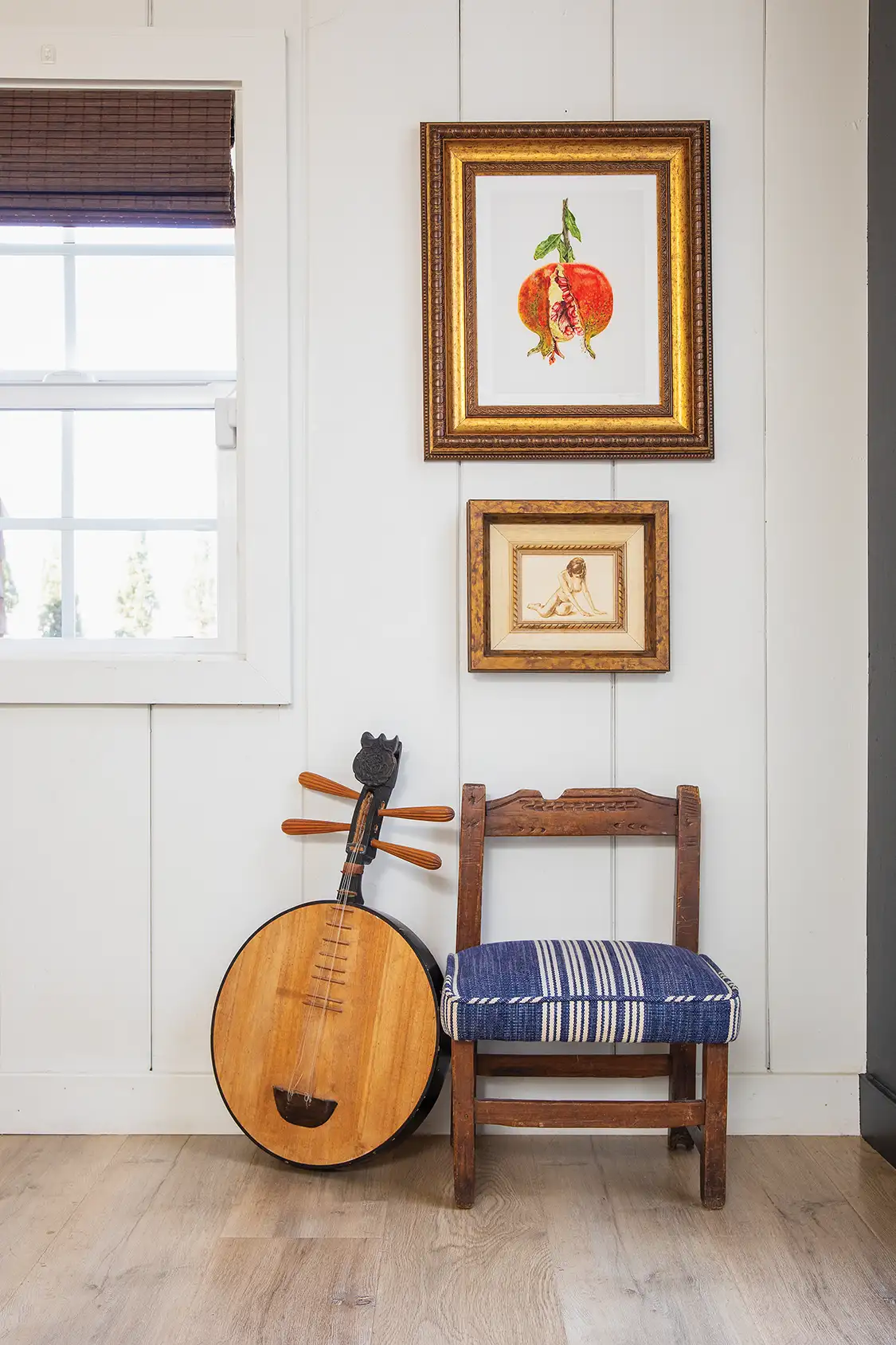 hallway vignette with vintage instrment, small chair and framed art
