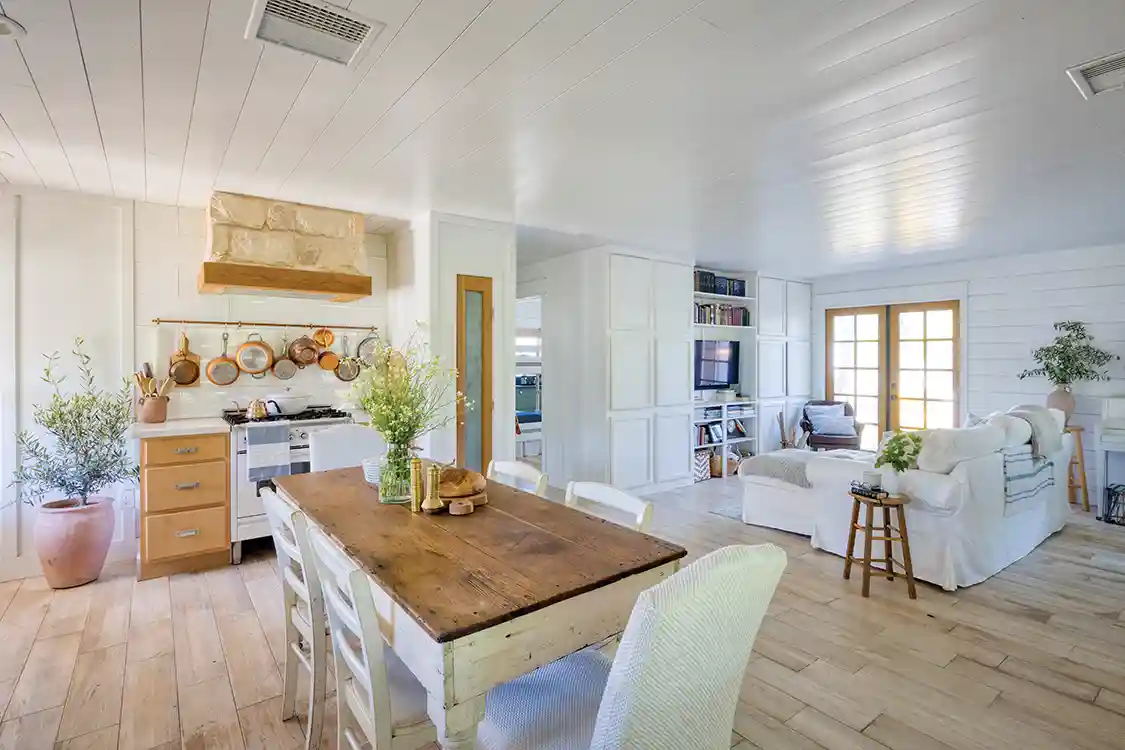 open concept kitchen dining and living room in little house on large property