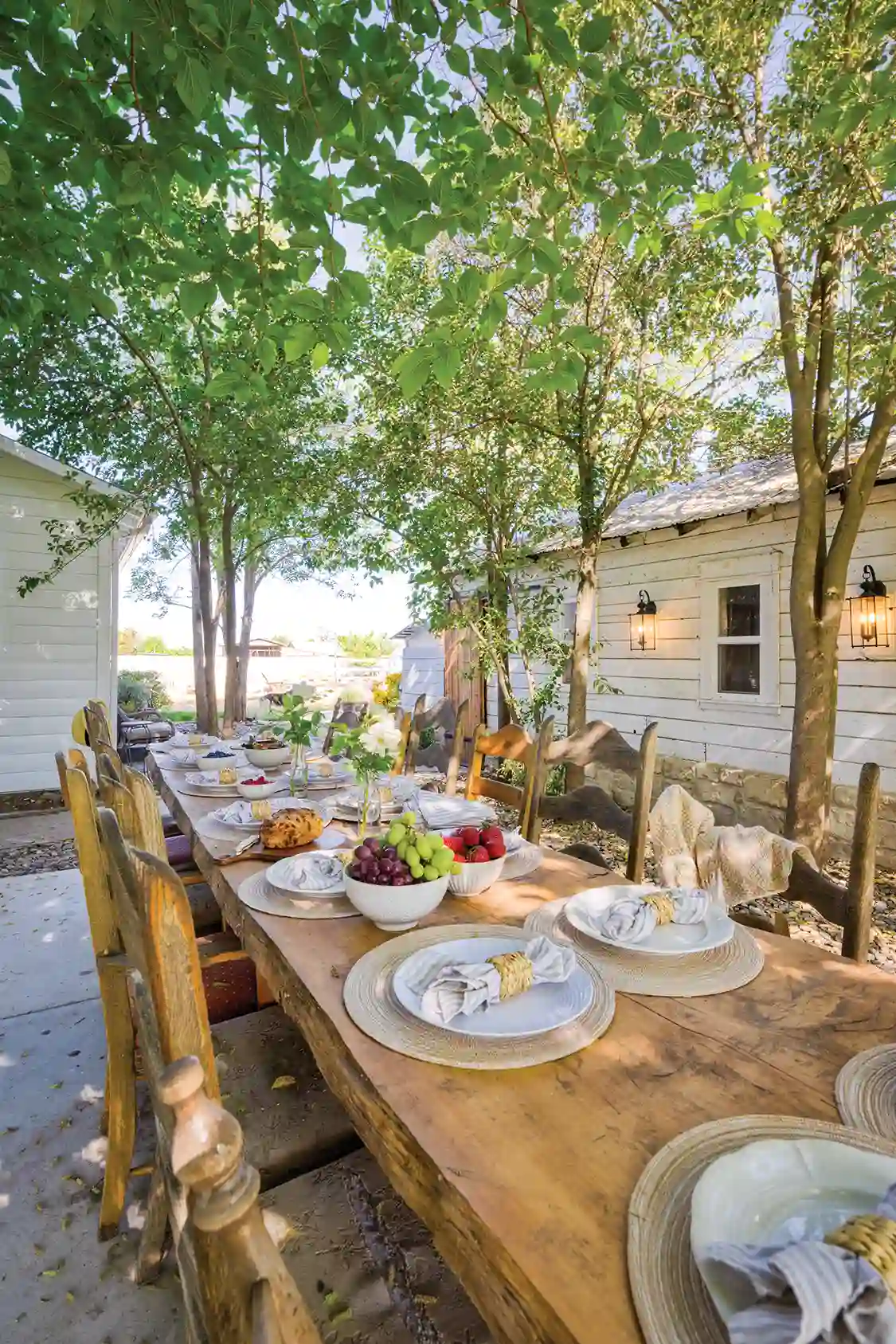 outdoor dining table set with bowls of fruit and beige woven placemats