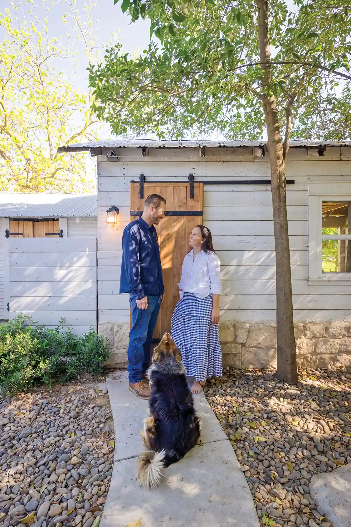 Rendi and husband outside their little house on a large property