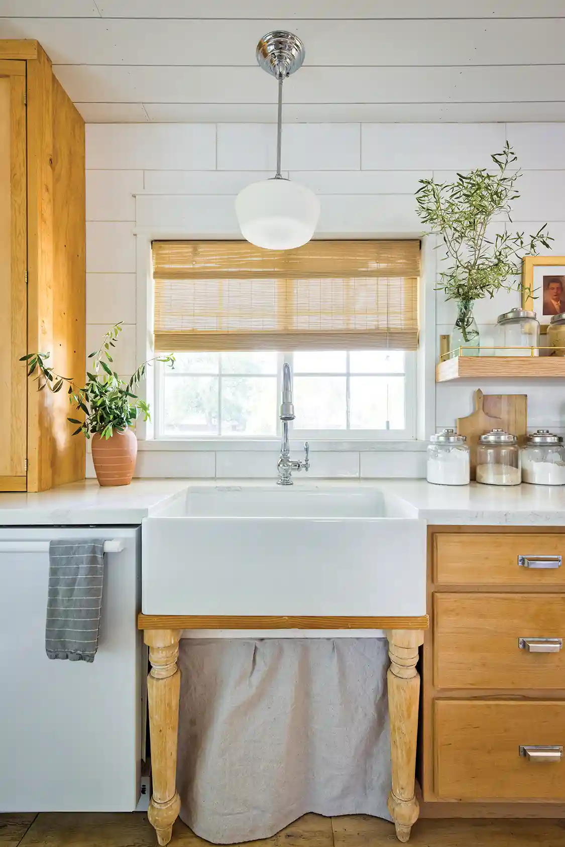 farmhouse sink with storage skirt and tree branches. as decor