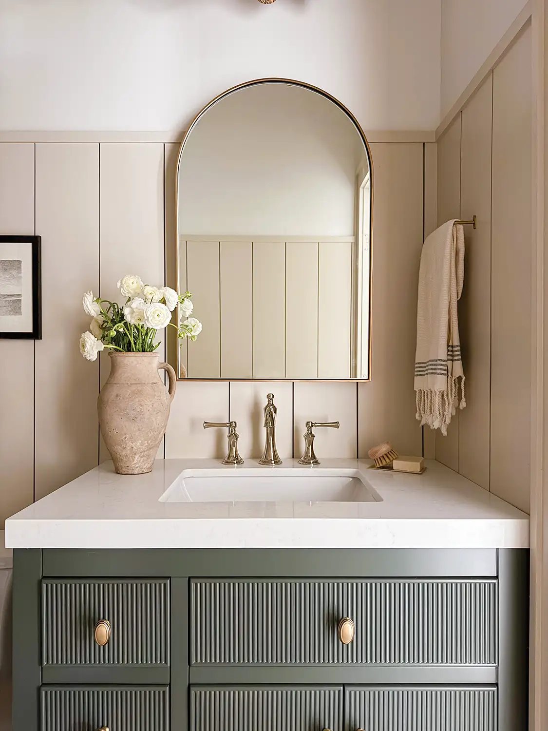 arch shaped mirror and green vanity in Project House Austin guest bathroom