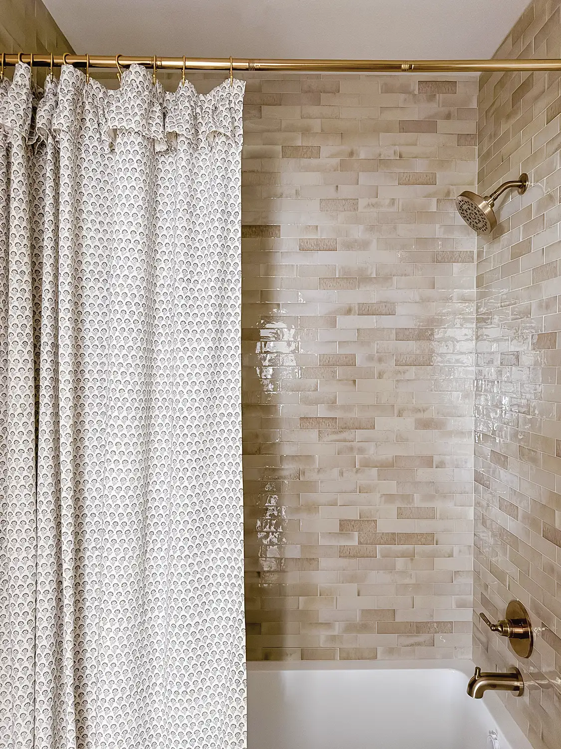shower with varied shades of beige and cream and bronze toned hardware