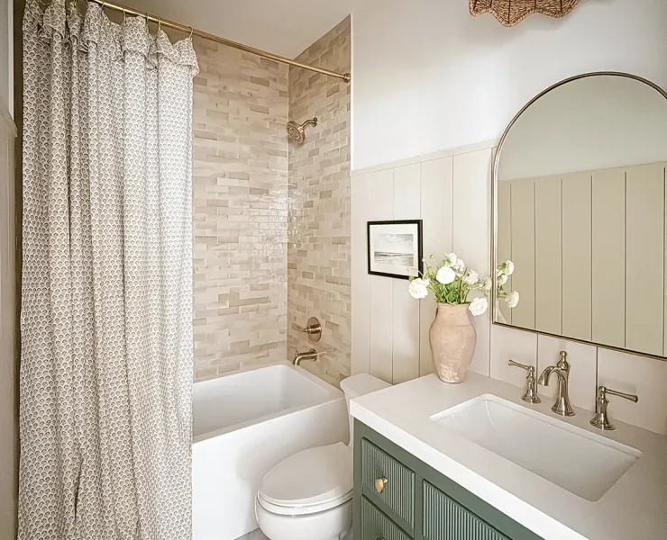 Project House Austin guest bathroom with green vanity and neutral tones